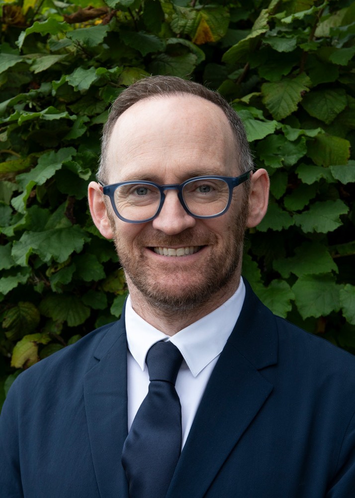 Photo of man smiling, facing camera.