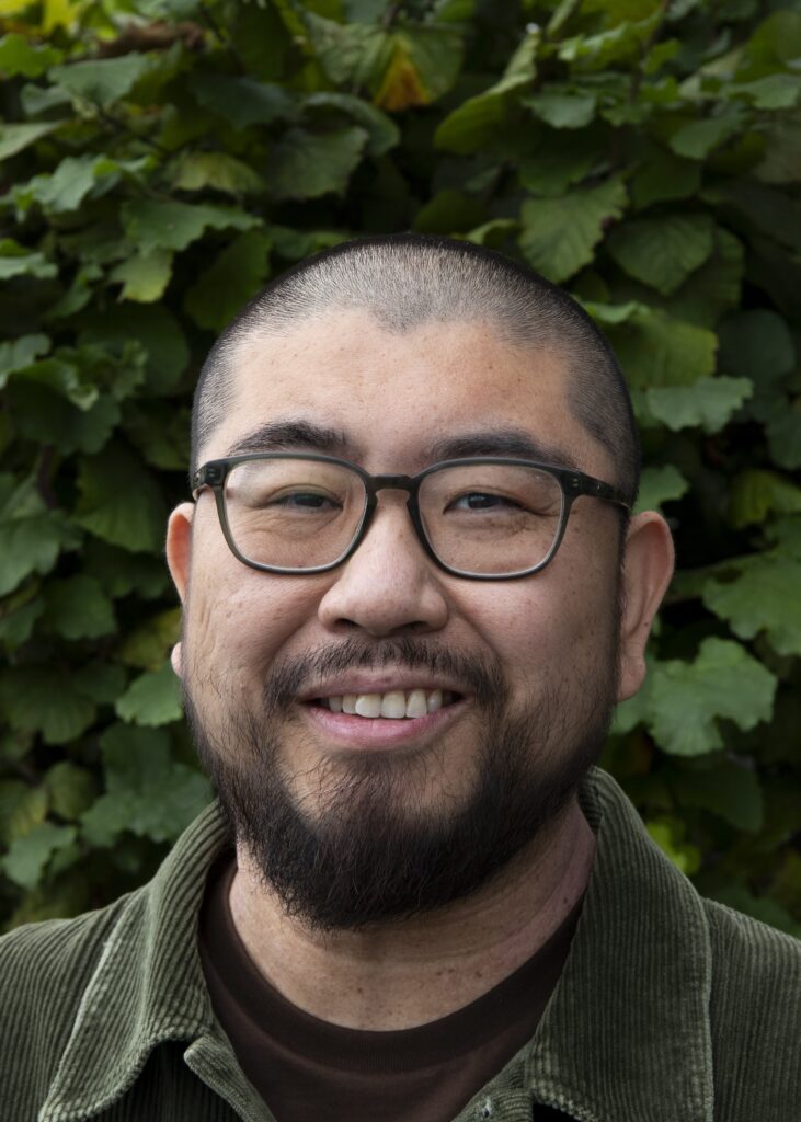 Headshot of man, smiling to camera.